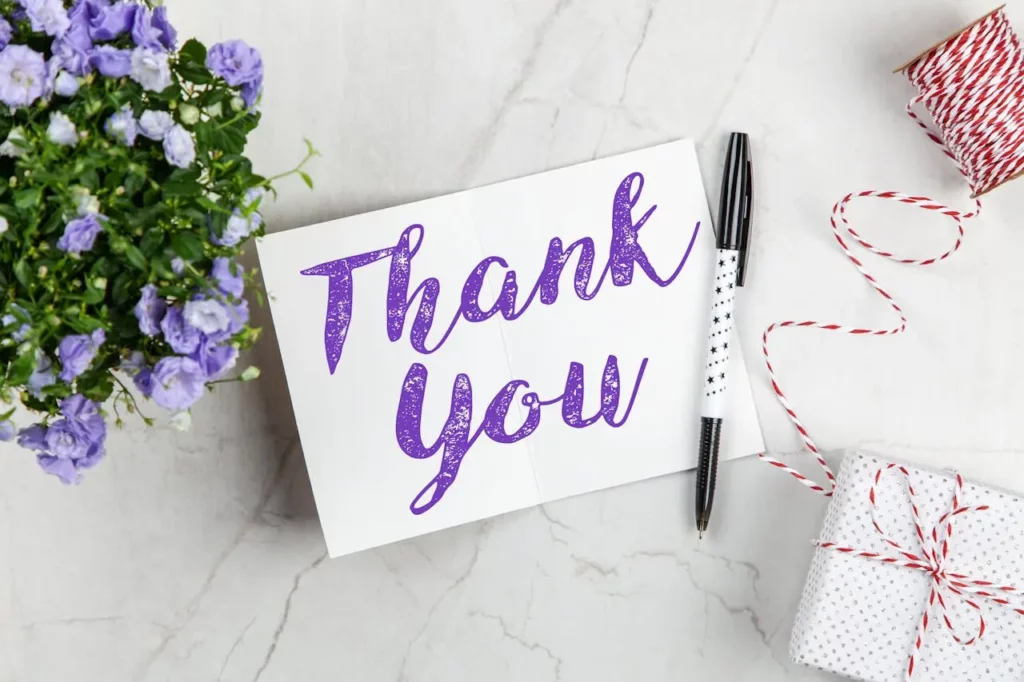 A real estate agent handing a thank-you card to a client