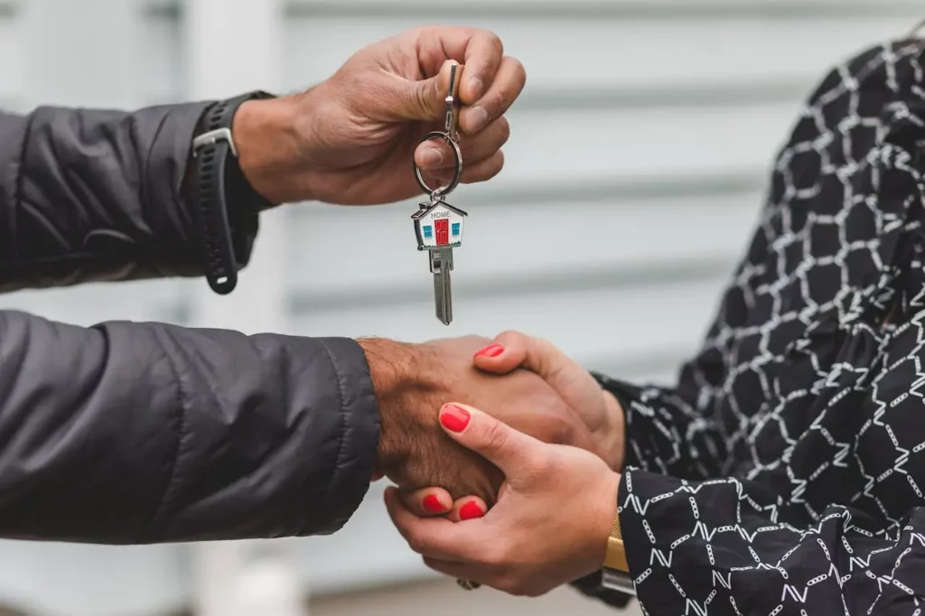 A happy couple receiving house keys from a realtor.