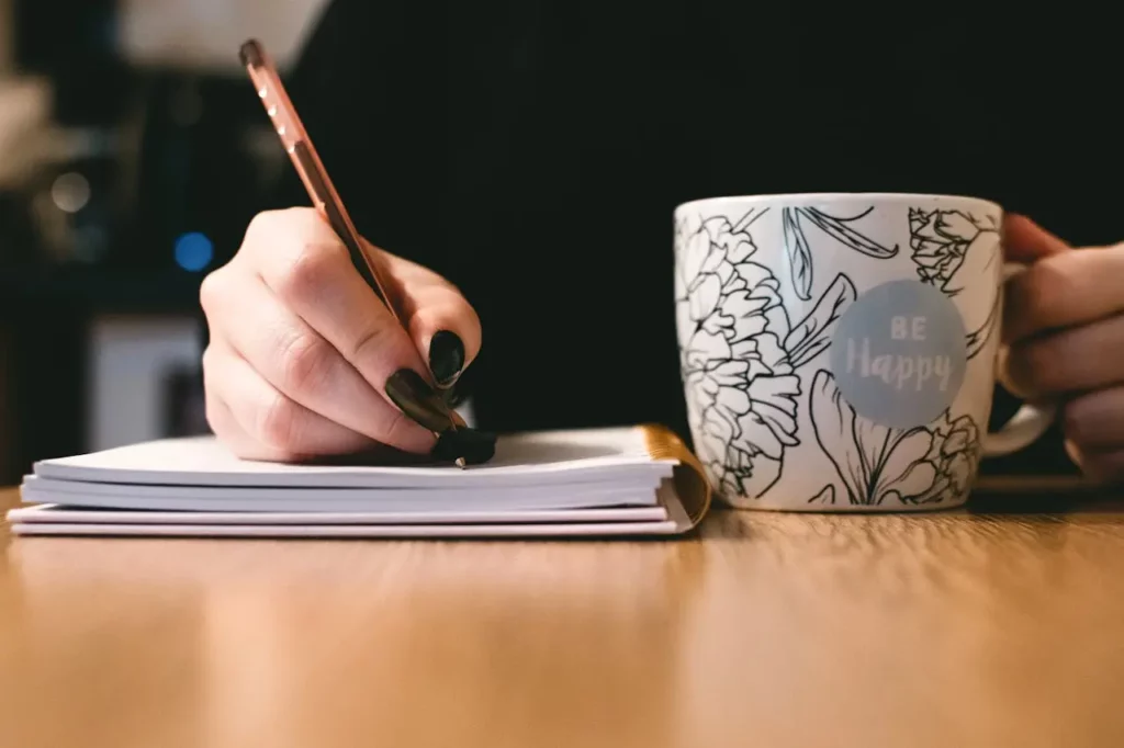 A real estate agent writing a handwritten thank-you note to a past client.
